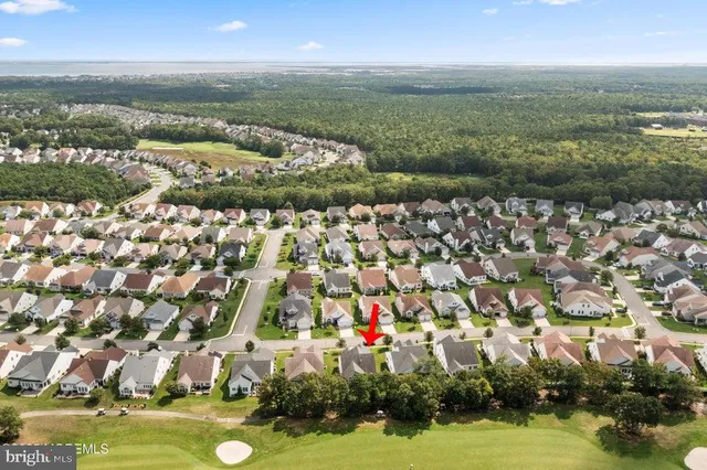 an aerial view of residential houses with outdoor space and lake view