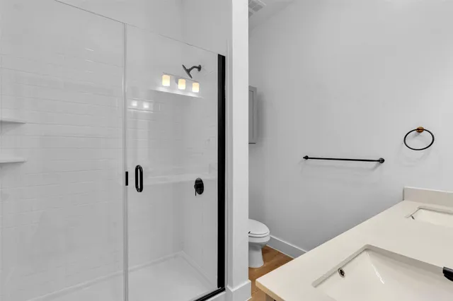 a bathroom with a sink a toilet and shower