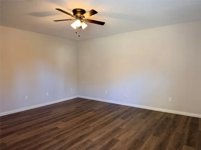 a view of a room with an empty space and a ceiling fan