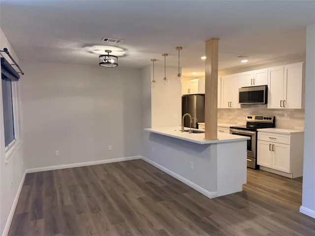 a kitchen with kitchen island white cabinets and appliances