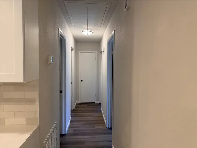 a view of a hallway with wooden floor