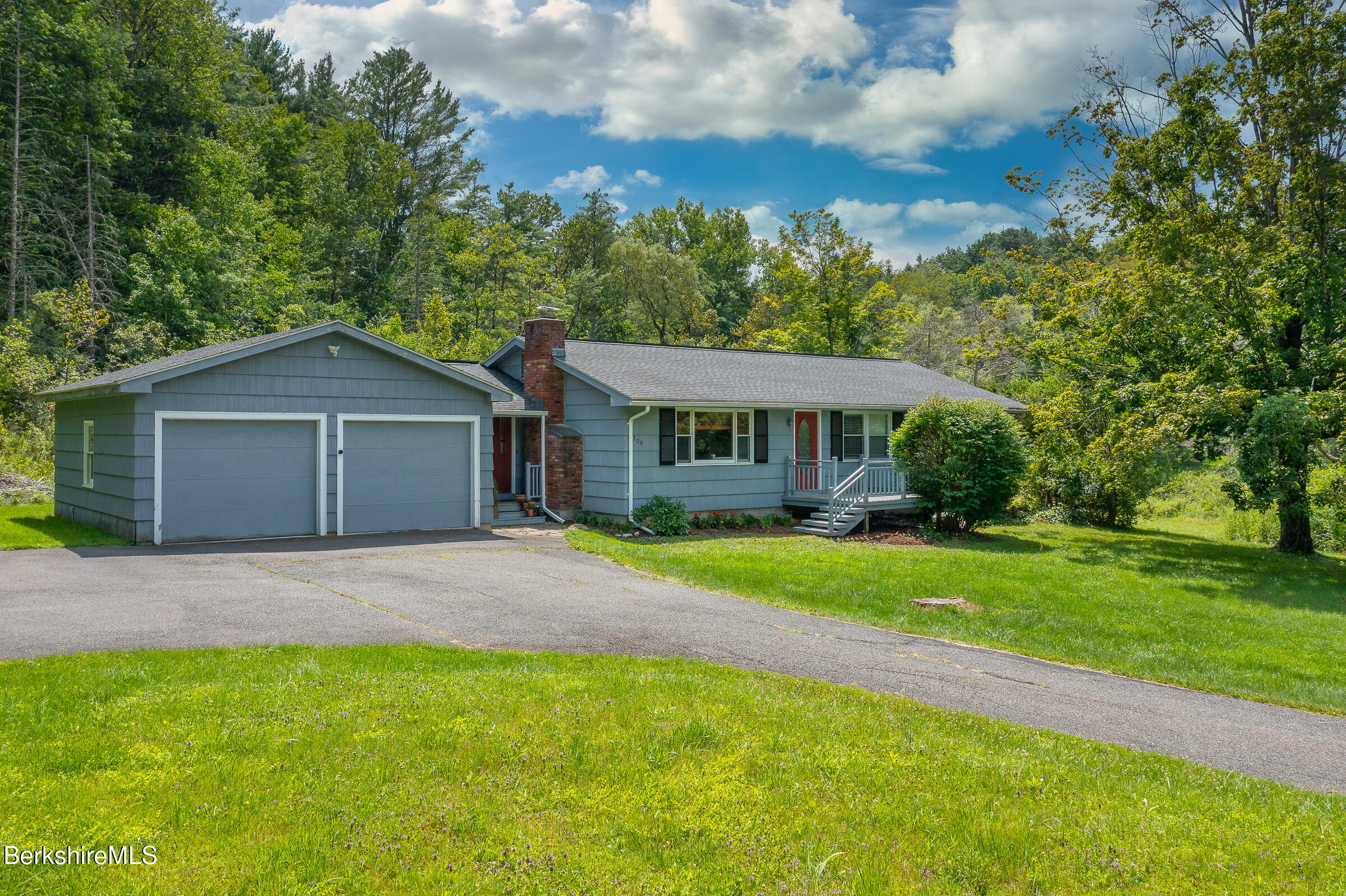 a front view of a house with a yard and trees