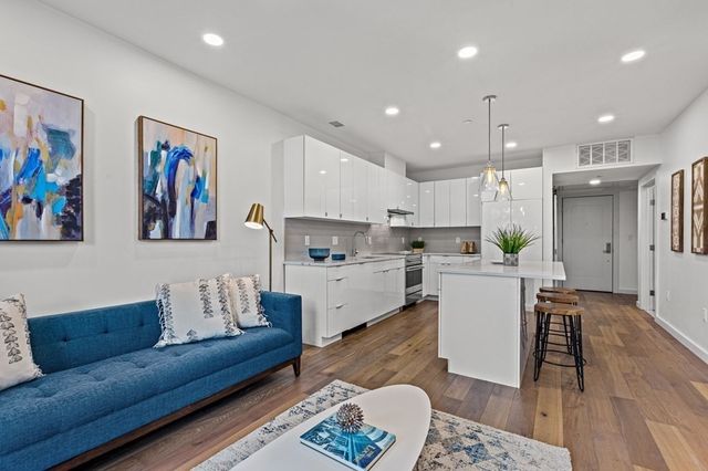 a living room with furniture and a dining table with kitchen view