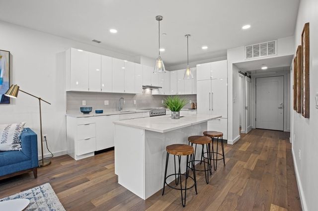 a kitchen with white cabinets and stainless steel appliances