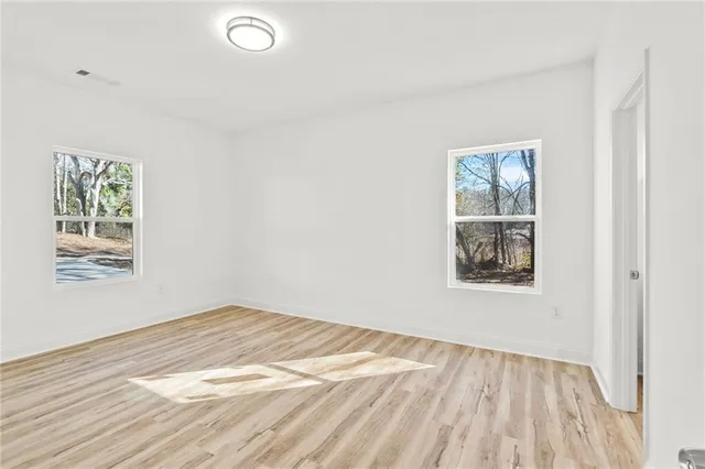 wooden floor in an empty room with a window
