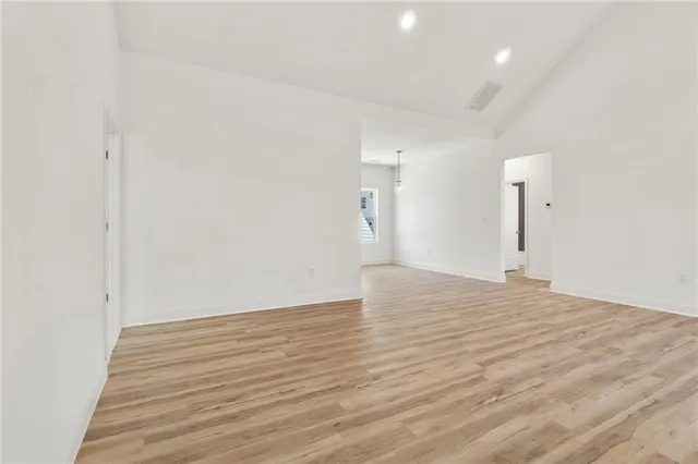 a view of empty room with wooden floor