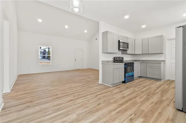 a kitchen with stainless steel appliances granite countertop a stove top oven a sink and dishwasher with wooden floor