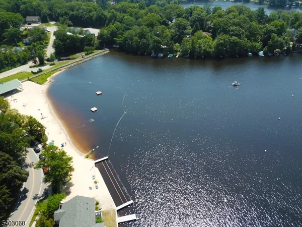 an aerial view of a house with a yard and lake view