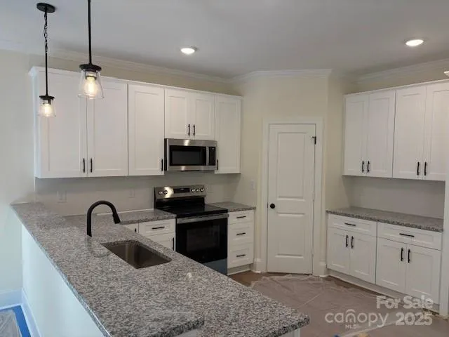 a kitchen with stainless steel appliances granite countertop a sink a stove and a refrigerator