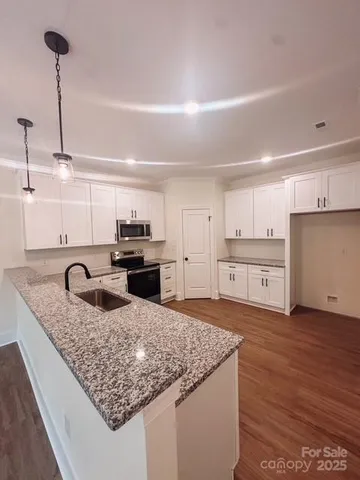 a kitchen with stainless steel appliances granite countertop a sink stove and cabinets
