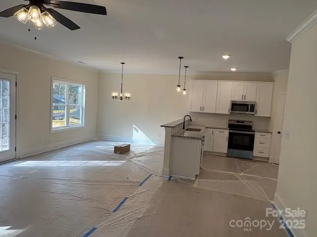 a kitchen with stainless steel appliances granite countertop a stove a sink and a refrigerator
