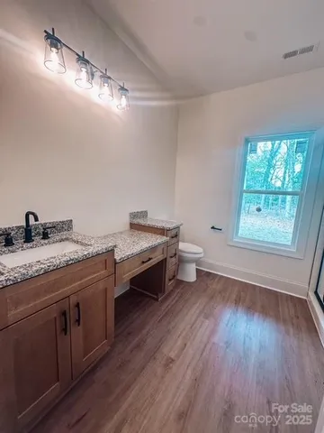 a spacious bathroom with a granite countertop sink toilet and a vanity