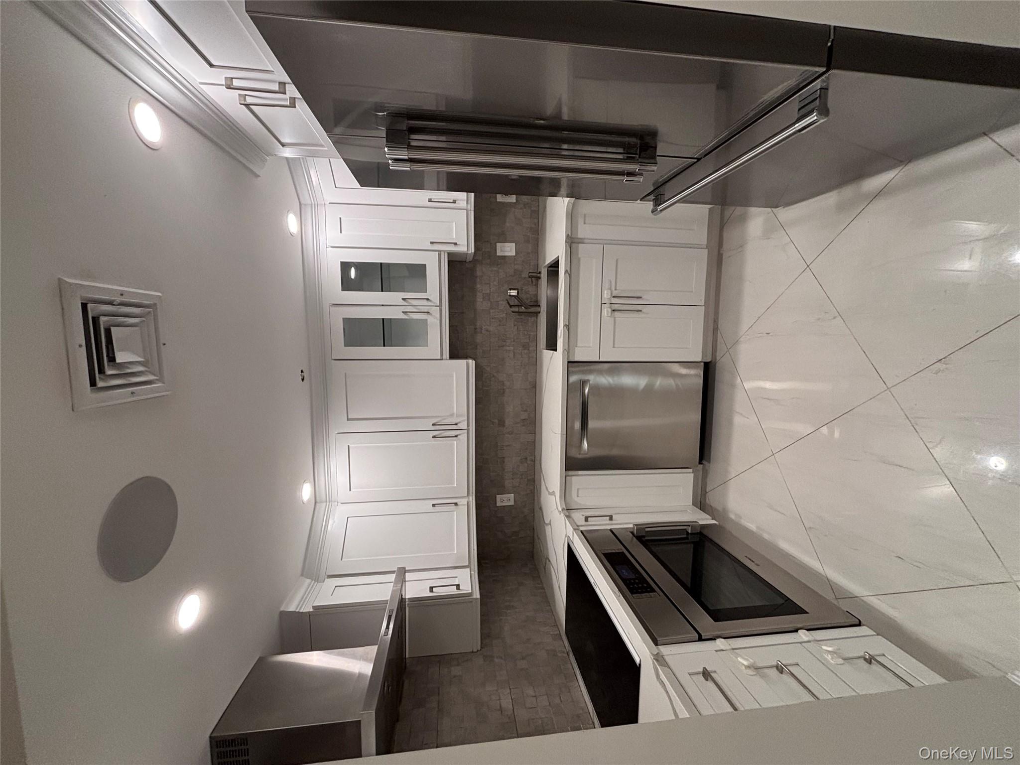 100 Cutter Mill Road, Unit 1B Great Neck, NY 11021 - Photo 12 of 16 a kitchen with a refrigerator sink and cabinets