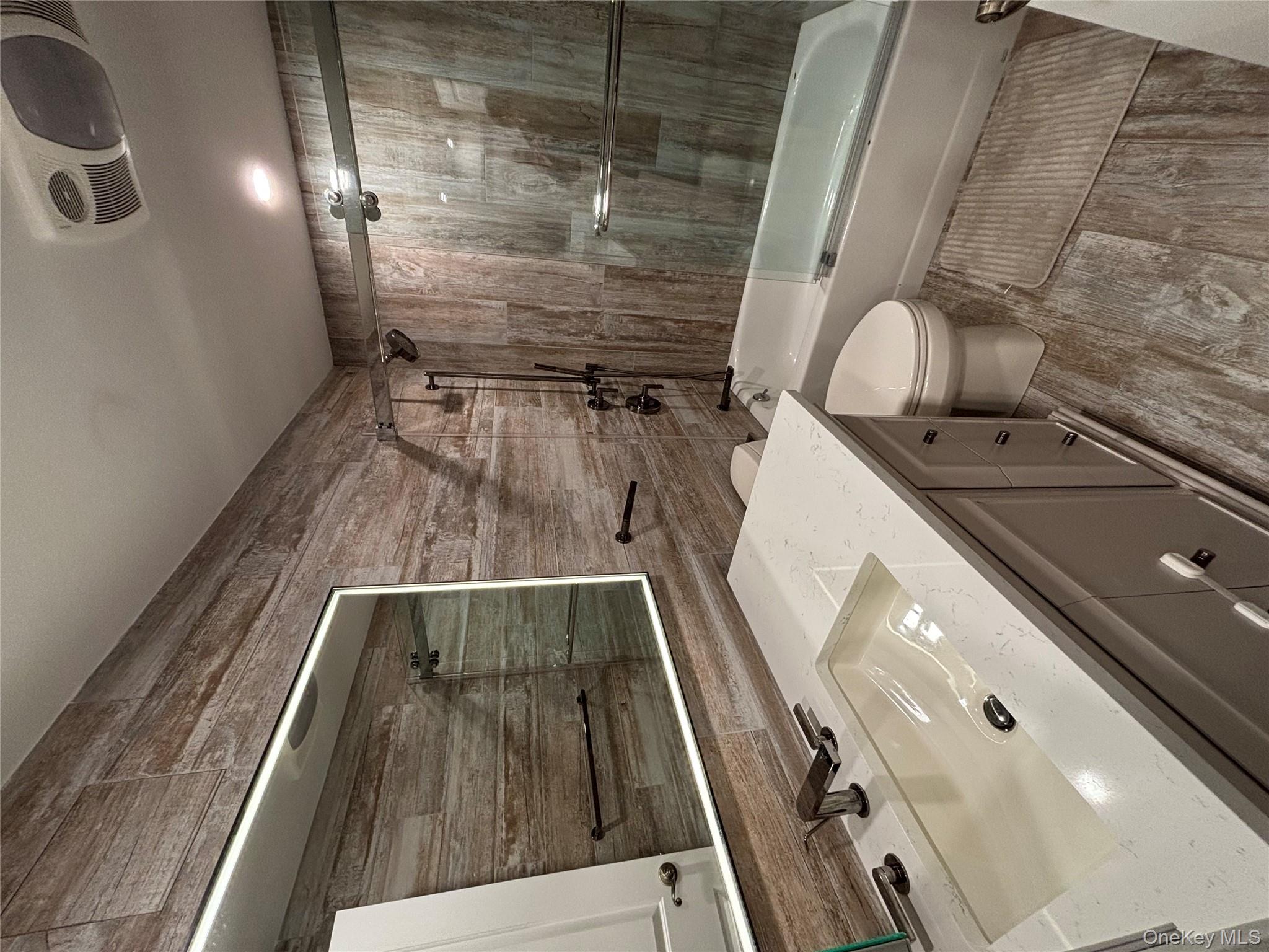 100 Cutter Mill Road, Unit 1B Great Neck, NY 11021 - Photo 6 of 16 a bathroom with a sink vanity mirror and toilet