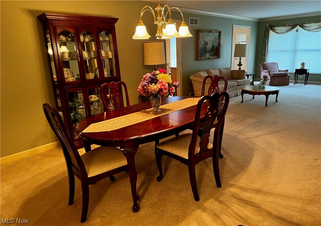 183 Mathews Road, Unit A Youngstown, OH 44512 - Photo 12 of 32 Dining room featuring ornamental molding, a chandelier, and light colored carpet