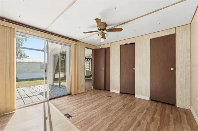 a view of a livingroom with wooden floor and a ceiling fan
