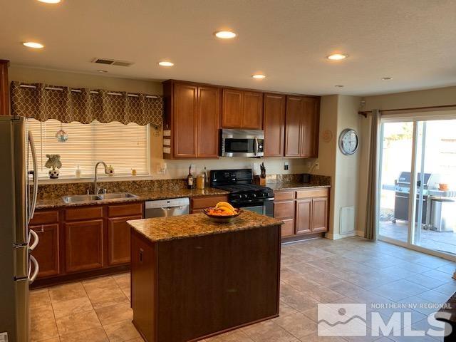 8920 Yeager Street Reno, NV 89506 - Photo 2 of 21 a kitchen with stainless steel appliances granite countertop a stove top oven a sink a refrigerator and a microwave