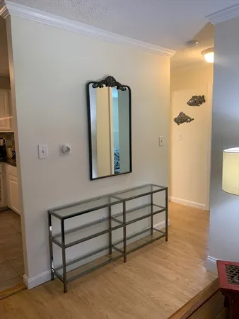 a view of a hallway with wooden floor and a bathroom