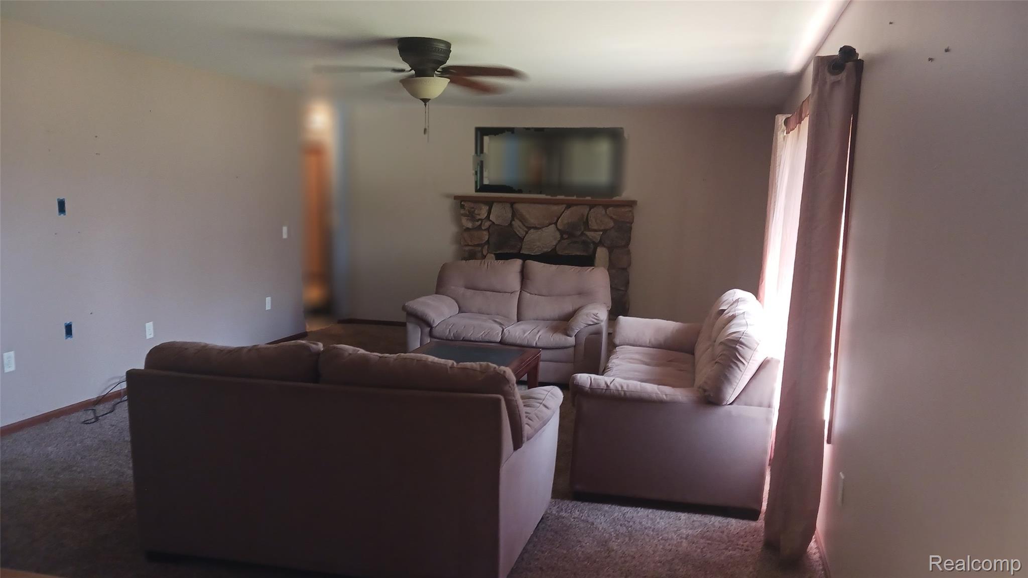 3803 Warner Road Cass City, MI 48726 - Photo 16 of 85 Carpeted living area with a ceiling fan and a fireplace