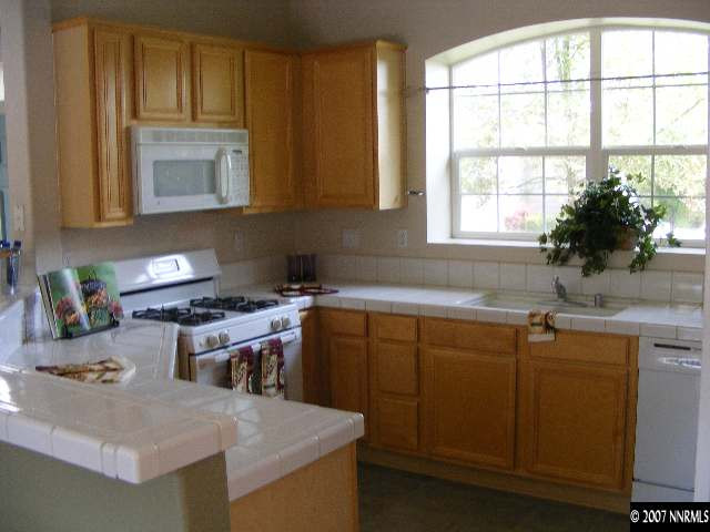 9629 Truckee Meadows Place Reno, NV 89521 - Photo 3 of 8 a kitchen with a sink stove top oven and cabinets