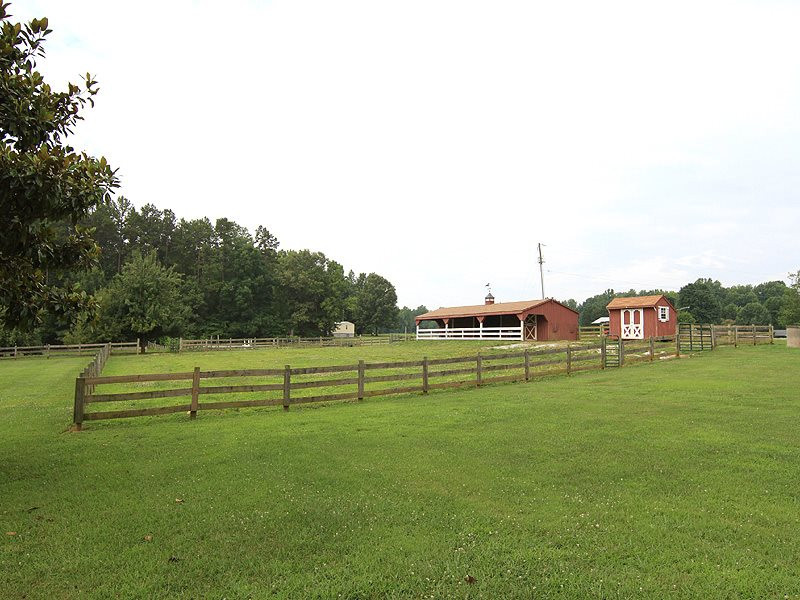 407 County Line Road Timberlake, NC 27583 - Photo 12 of 21 Great pasture with 3 board fencing and barn/stable, water, and electricity. Also has riding ring and acres of room for additional pasture. There is a separate shed for feed storage. Pasture and Barn