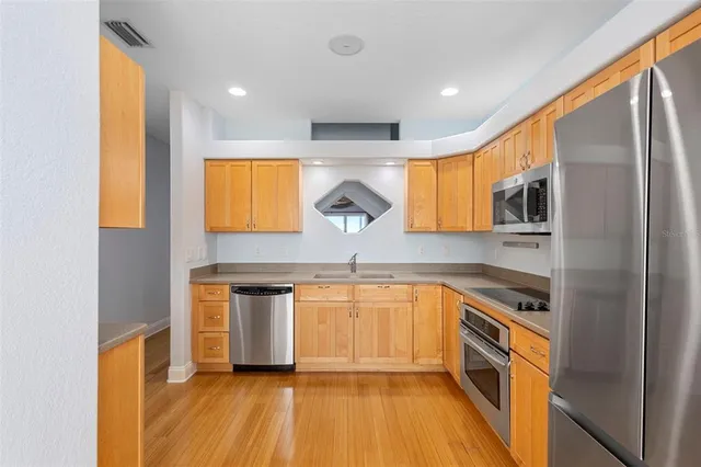 a kitchen with stainless steel appliances granite countertop a sink and a stove top oven