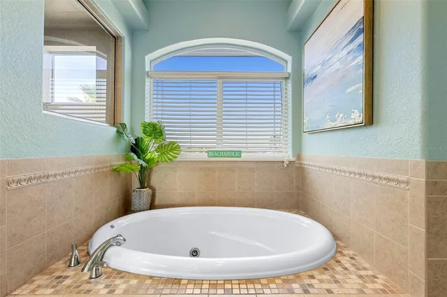 a white bath tub sitting in a bathroom next to a window