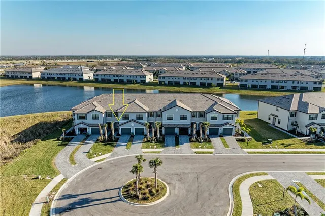 an aerial view of a house with swimming pool and outdoor seating