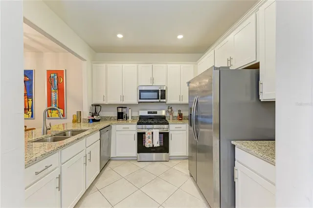 a kitchen with white cabinets and stainless steel appliances