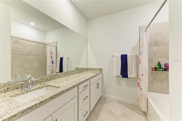 a bathroom with a granite countertop sink and a toilet