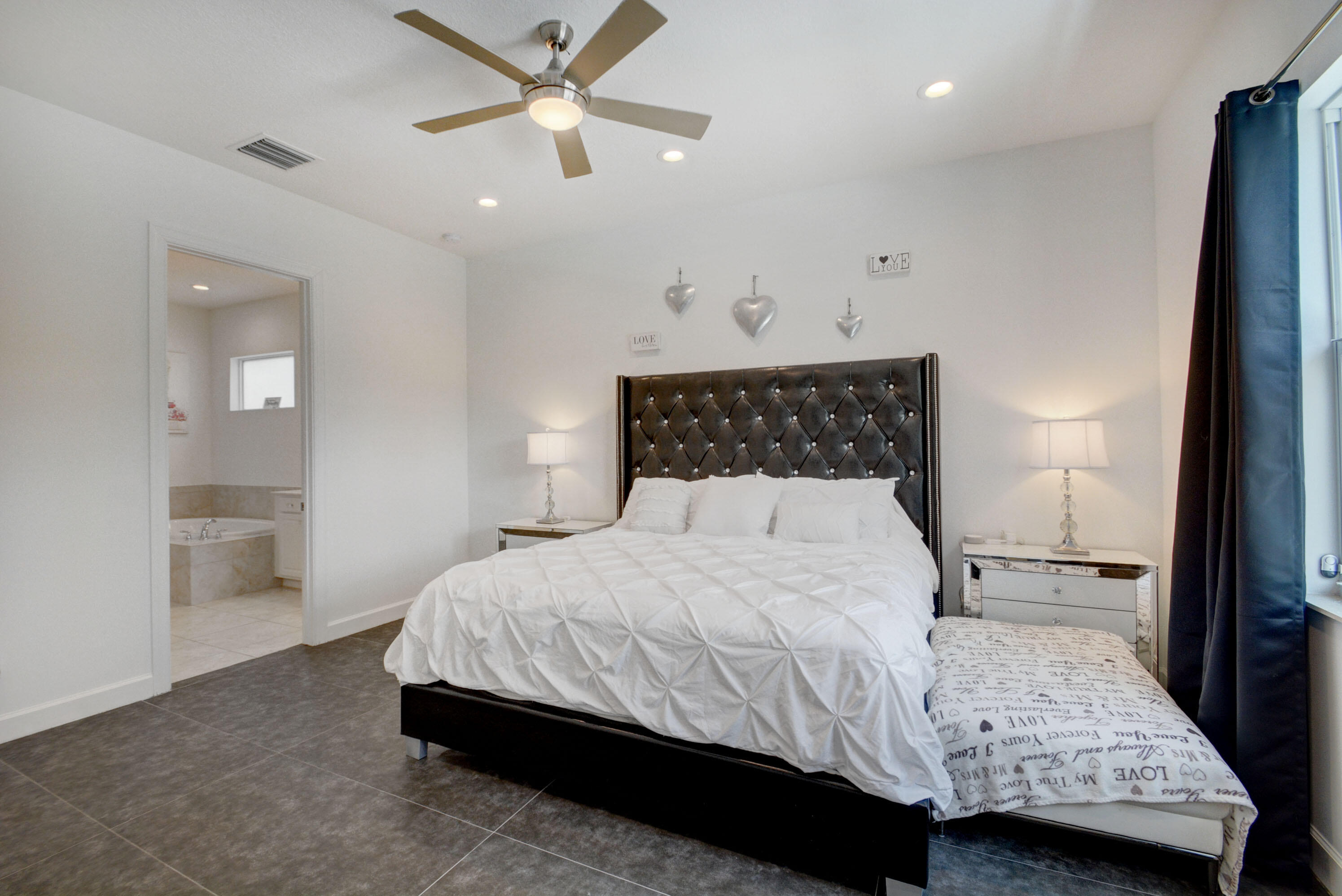 5251 Beland Drive Lake Worth, FL 33467 - Photo 27 of 56 a bedroom with a bed and a chandelier