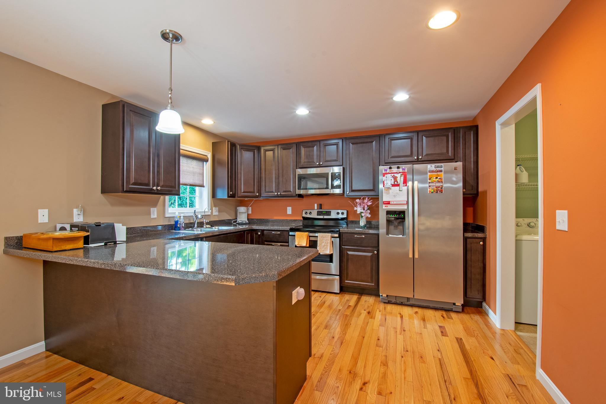 54 Minner Street Houston, DE 19954 - Photo 19 of 55 a kitchen with stainless steel appliances granite countertop a refrigerator a sink dishwasher a stove and a dining table with wooden floor