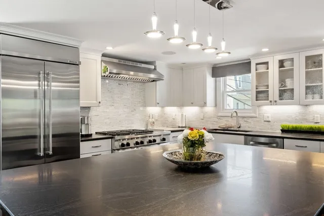 a kitchen with stainless steel appliances granite countertop a stove and a refrigerator