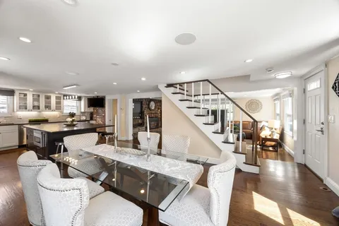 a living room with couches and kitchen view with wooden floor