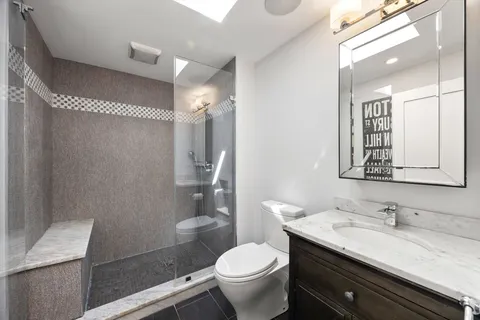 a bathroom with a granite countertop sink toilet and shower
