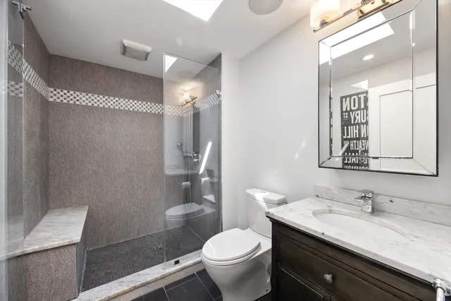 a bathroom with a granite countertop sink toilet and shower