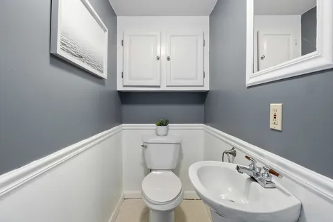 a bathroom with a toilet sink and mirror