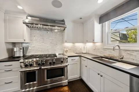 a kitchen with stainless steel appliances granite countertop a sink stove and cabinets