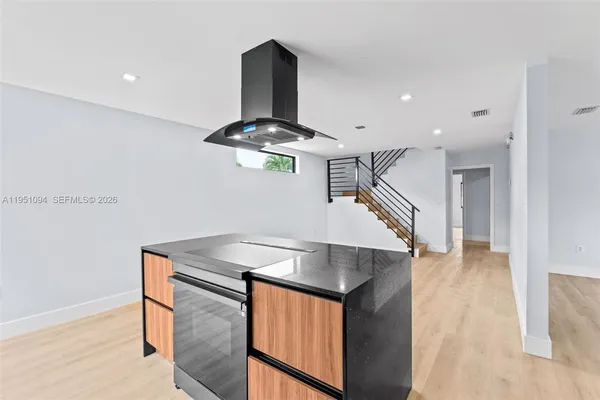 a kitchen with stainless steel appliances kitchen island a chimney a sink and a stove
