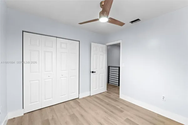 an empty room with a ceiling fan and window