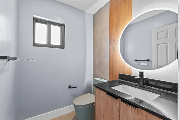 a bathroom with a sink a toilet a mirror and shower