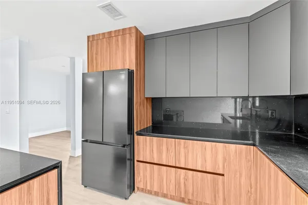 a kitchen with stainless steel appliances granite countertop a refrigerator a sink and a stove