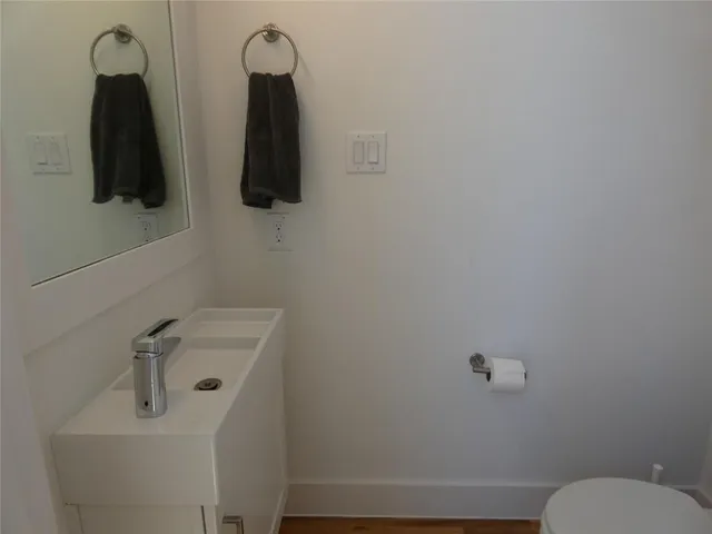 a bathroom with a toilet sink and mirror