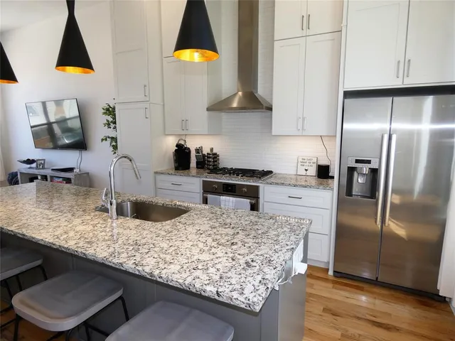 a kitchen with granite countertop a sink a counter top space appliances and cabinets