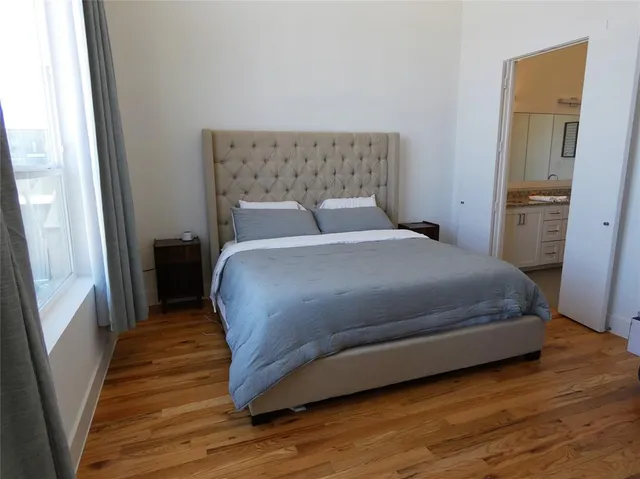a bedroom with a bed and wooden floor
