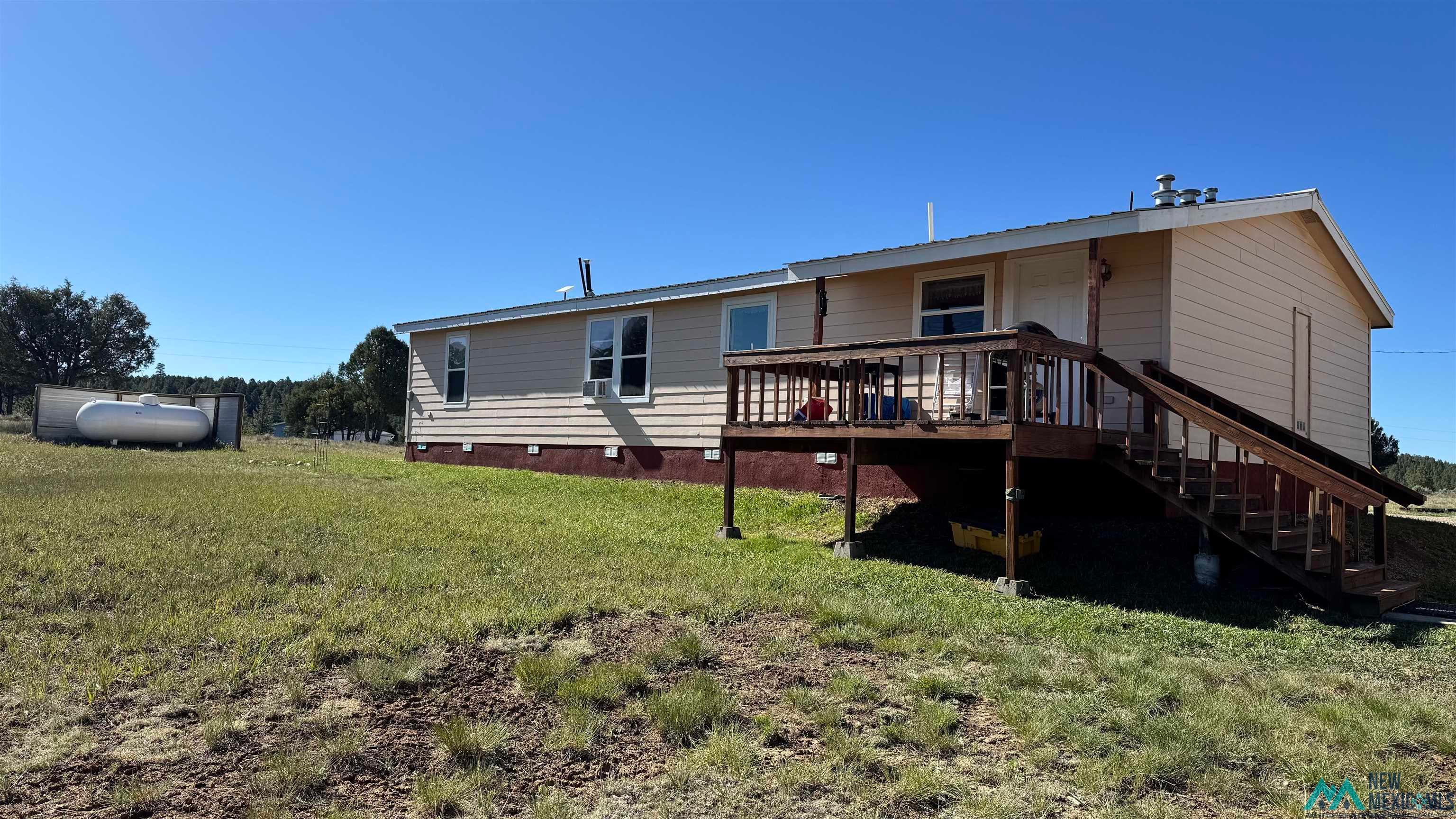 16 Overlook Road Los Ojos, NM 87551 - Photo 3 of 39 Exterior siding in a neutral tone with a contrasting darker foundation