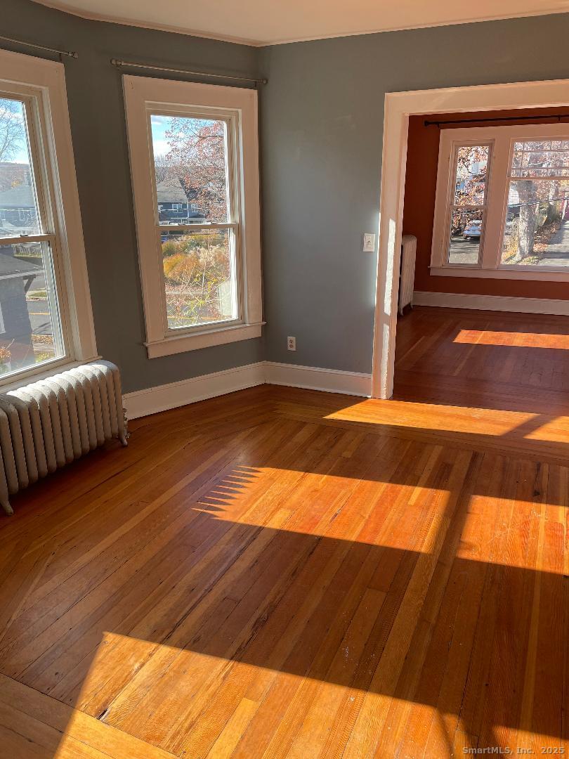 42 Oakland Street, Unit 2 Bristol, CT 06010 - Photo 5 of 13 a view of an empty room with wooden floor and a window