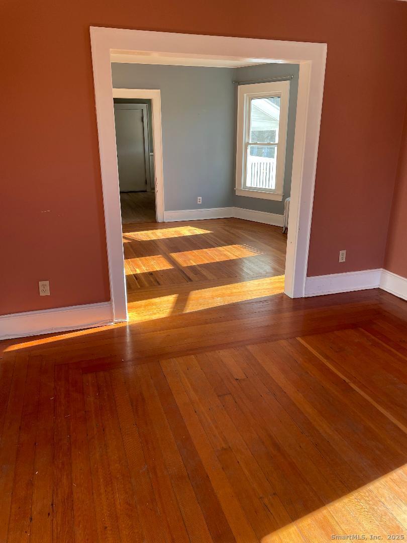 42 Oakland Street, Unit 2 Bristol, CT 06010 - Photo 6 of 13 a view of an empty room with window and wooden floor