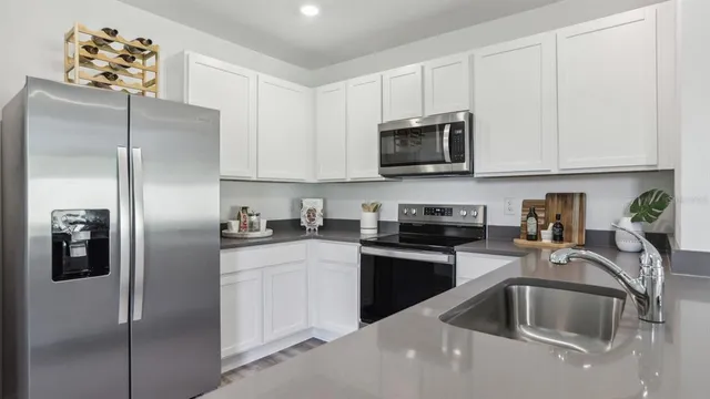 a kitchen with stainless steel appliances granite countertop a refrigerator sink and microwave