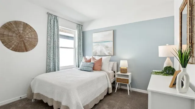 a bedroom with a bed a couch and a potted plant